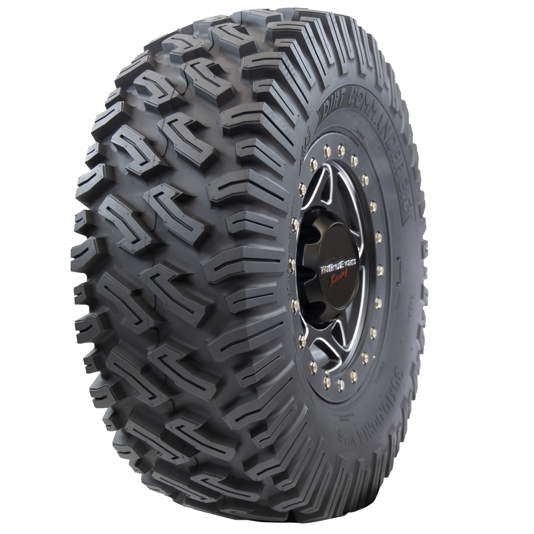 Angle view of Dirt Commander 2.0 ATV/UTV tire, showing off the tread, a section of the sidewall, and the rim. The tire features a sturdy square shoulder profile for maintaining grip and bite, ensuring optimal performance even at extreme speeds and during sharp cornering.