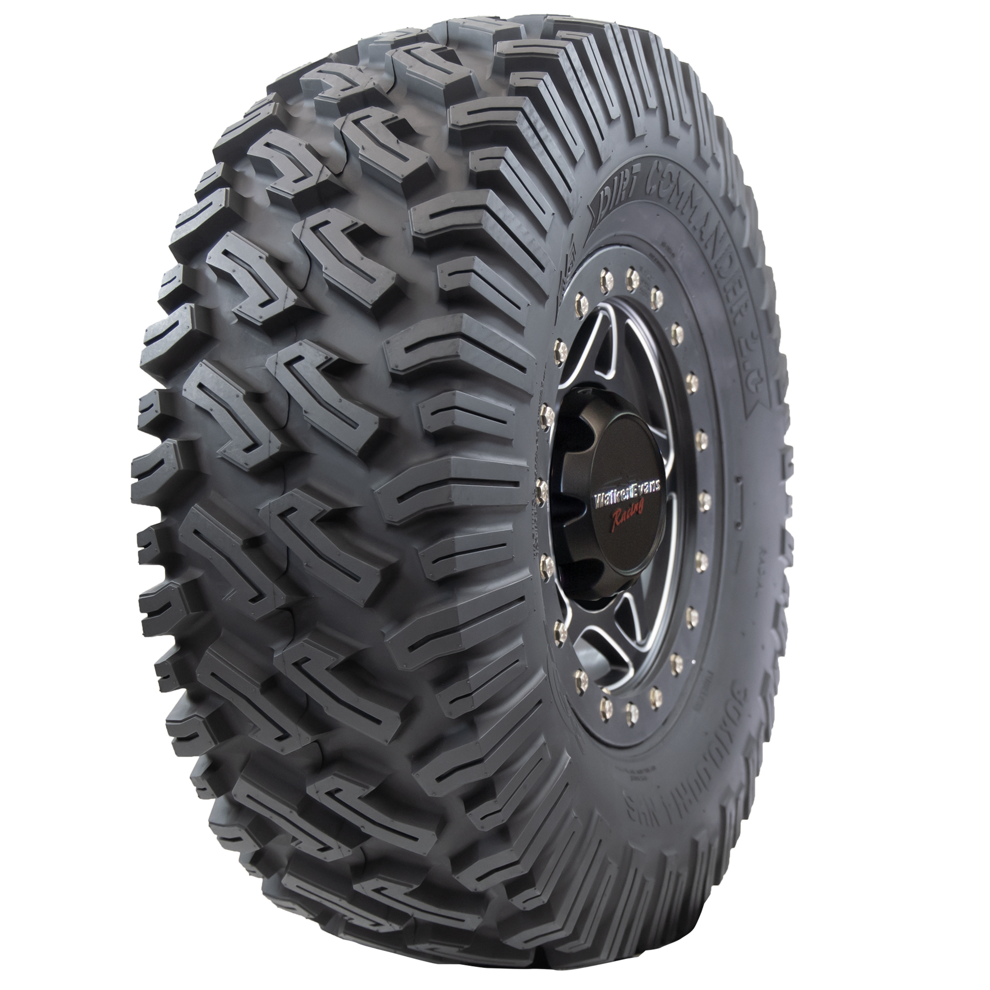 Angle view of Dirt Commander 2.0 ATV/UTV tire, showing off the tread, a section of the sidewall, and the rim. The tire features a sturdy square shoulder profile for maintaining grip and bite, ensuring optimal performance even at extreme speeds and during sharp cornering.